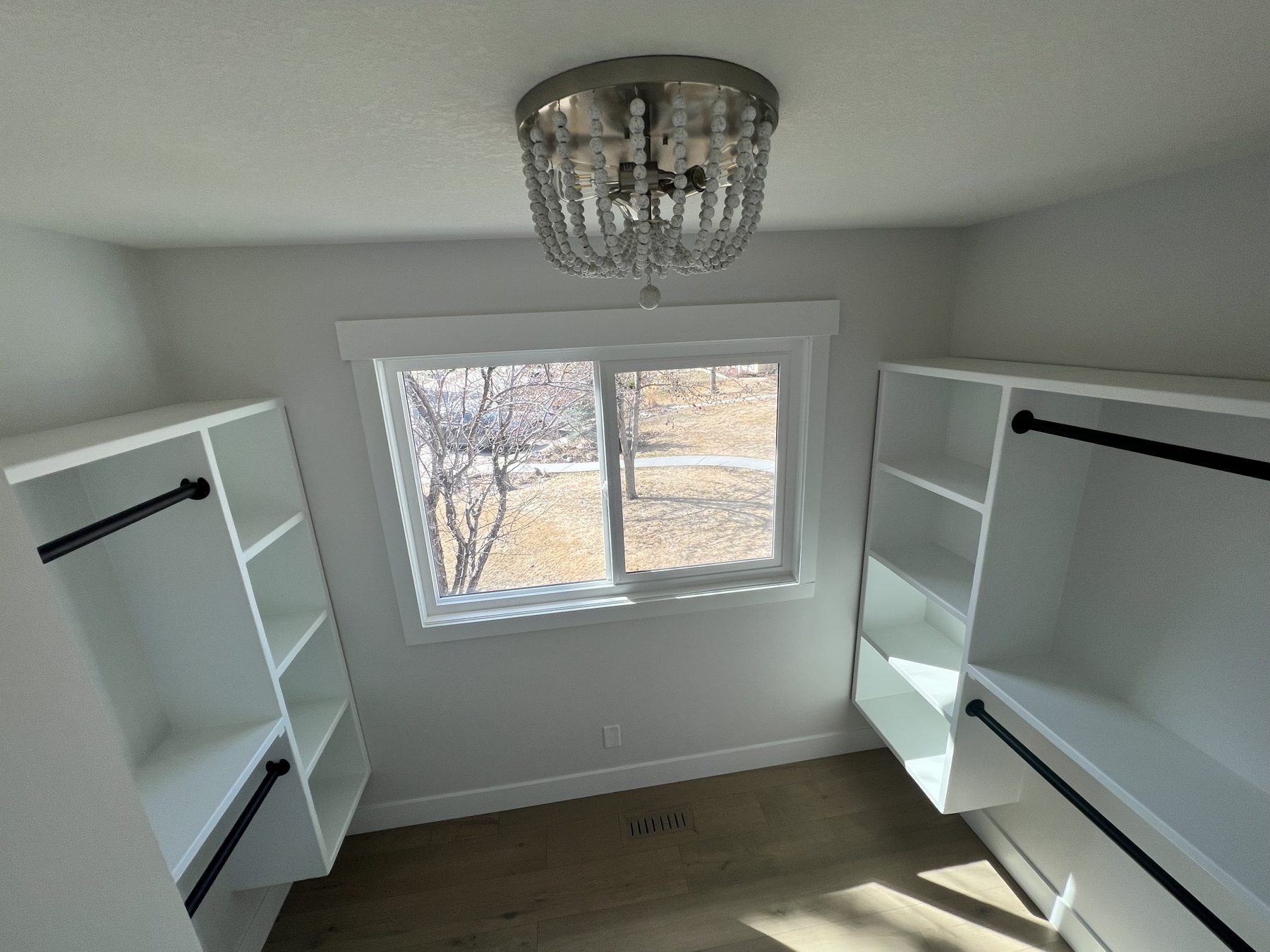 Newly built white closet with shelves and hanging rods — 720 Lake Twintree Crescent SE, Calgary
