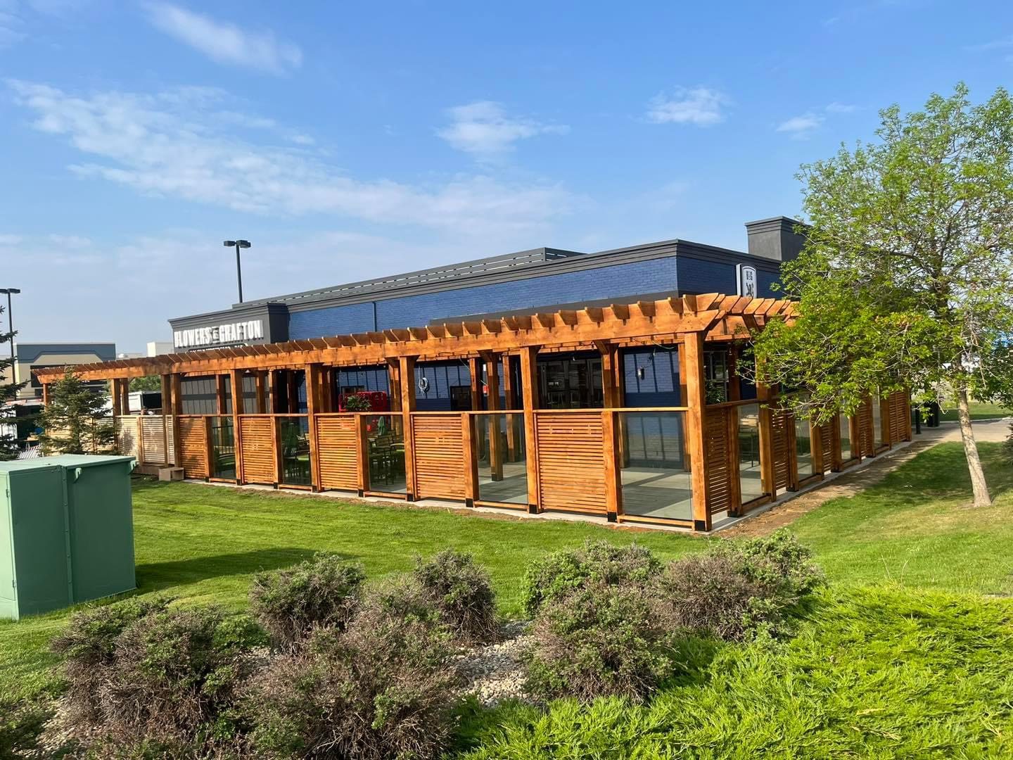 Wooden pergola and slatted glass patio extension on blue building — Blowers and Grafton (Lethbridge)