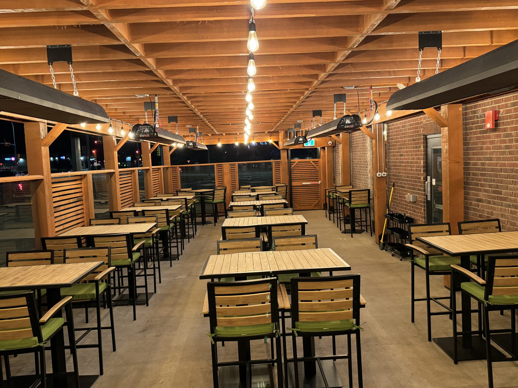 Outdoor patio seating with wood ceiling, heaters, and cafe tables — Blowers and Grafton (Medicine Hat)