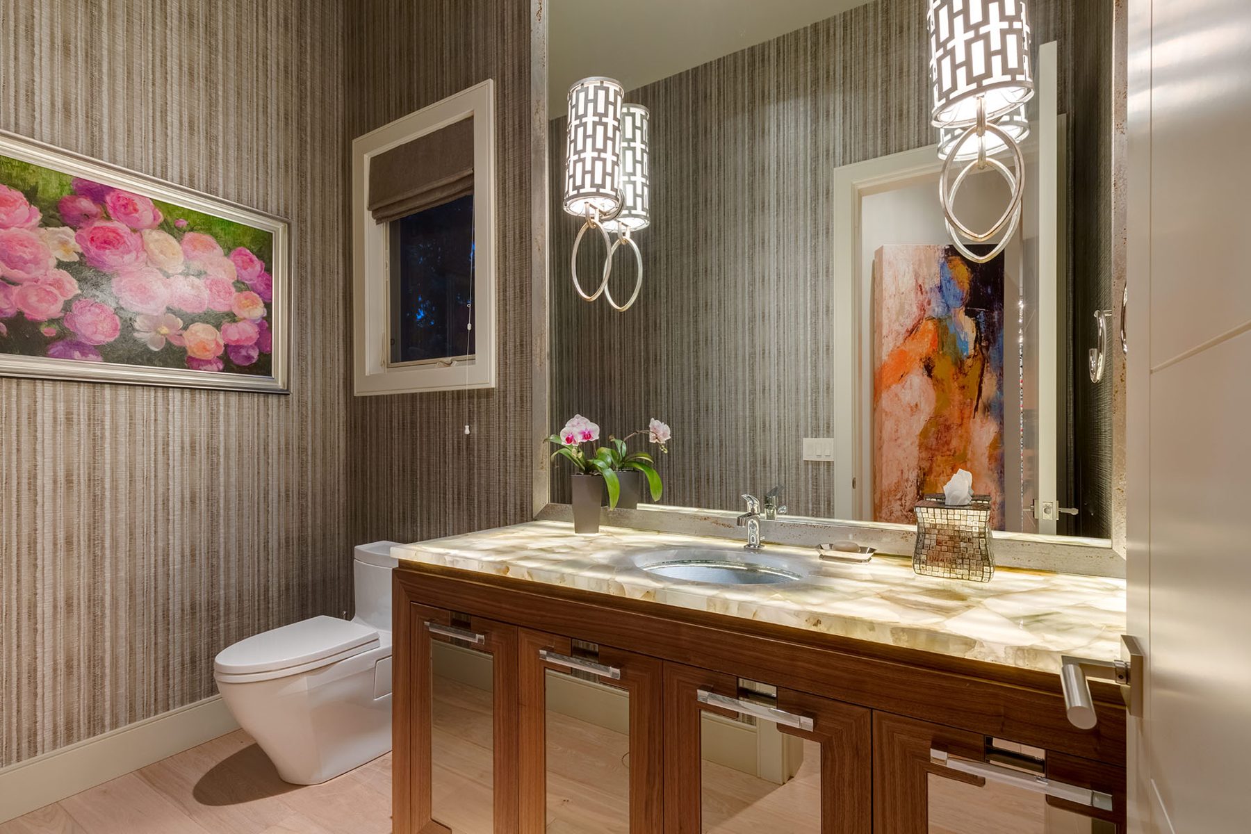 Modern bathroom with marbled countertop, wood vanity, and abstract art — Evolution
