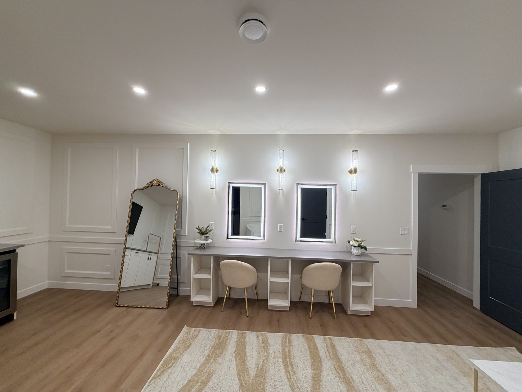 Vanity area with lighted mirrors and two chairs — The Barron Venue