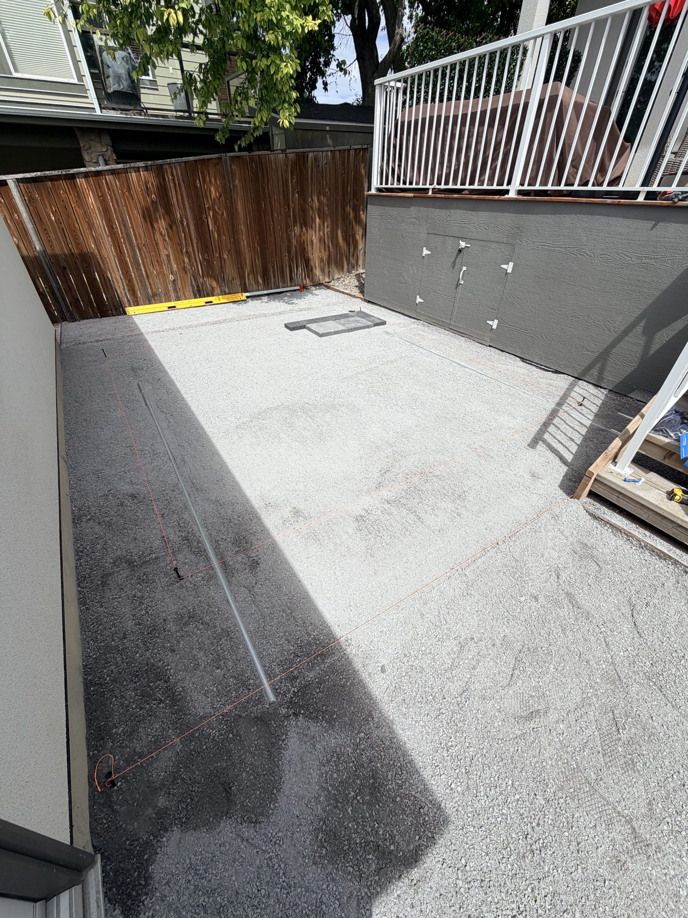 Gravel patio prep with leveling tool and orange string lines — 3505 41 Street SW, Calgary