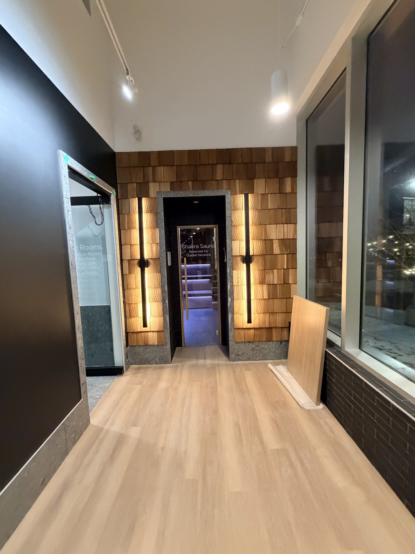 Hallway with wood-plank walls, illuminated entrance to sauna with stairs — Cedar Steam and Spa (Trinity Hills)