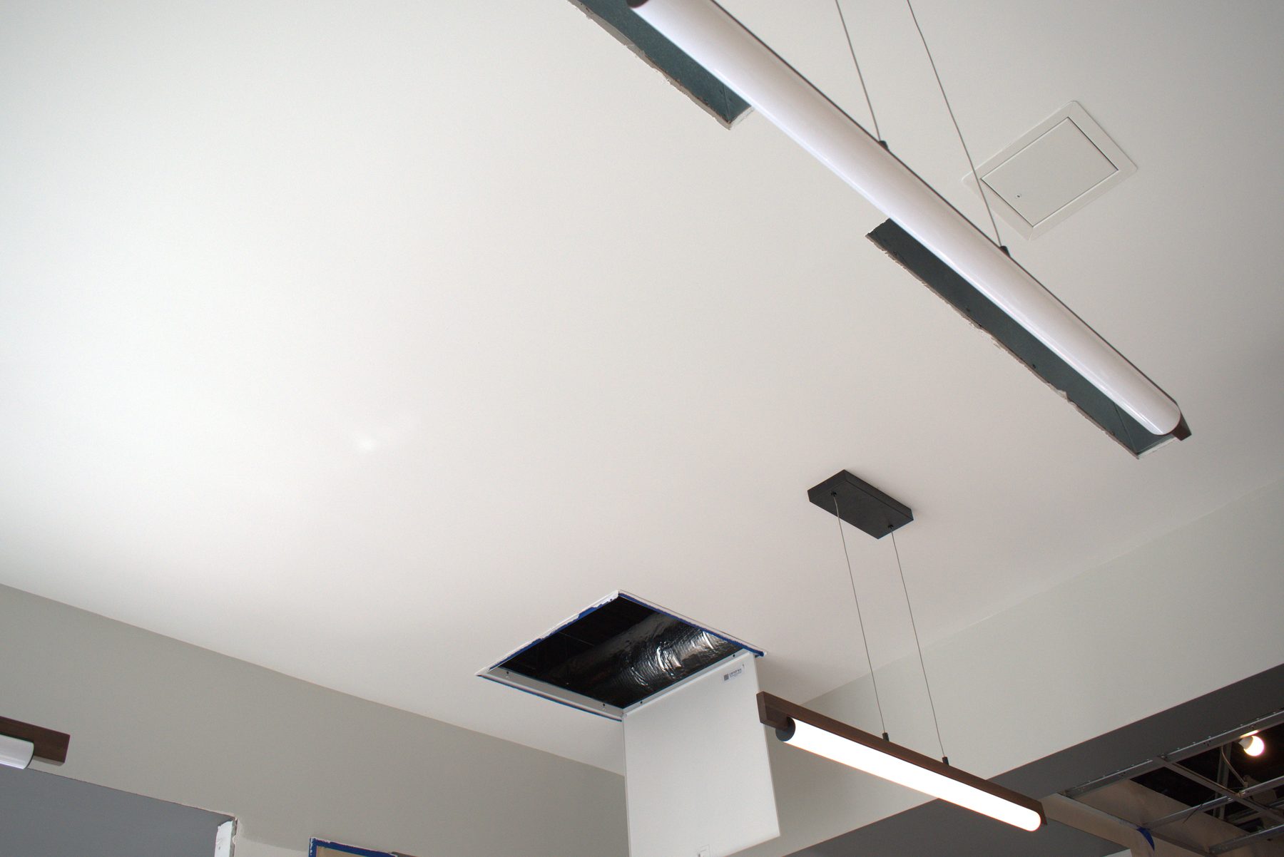 Ceiling renovation with open ductwork and new light fixtures — ONE8T (West District)