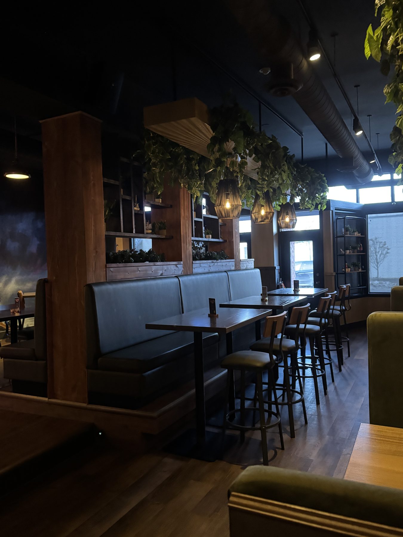 Restaurant dining area with dark booths, wood accents, and plants — Blowers and Grafton (Mission)