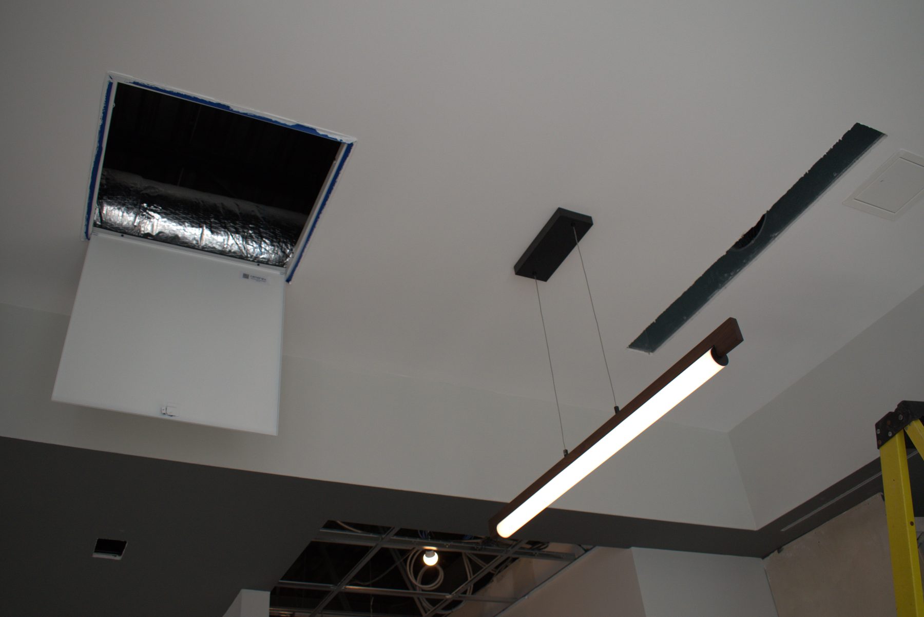 New linear light fixture, HVAC opening, and ceiling panel installation — ONE8T (West District)