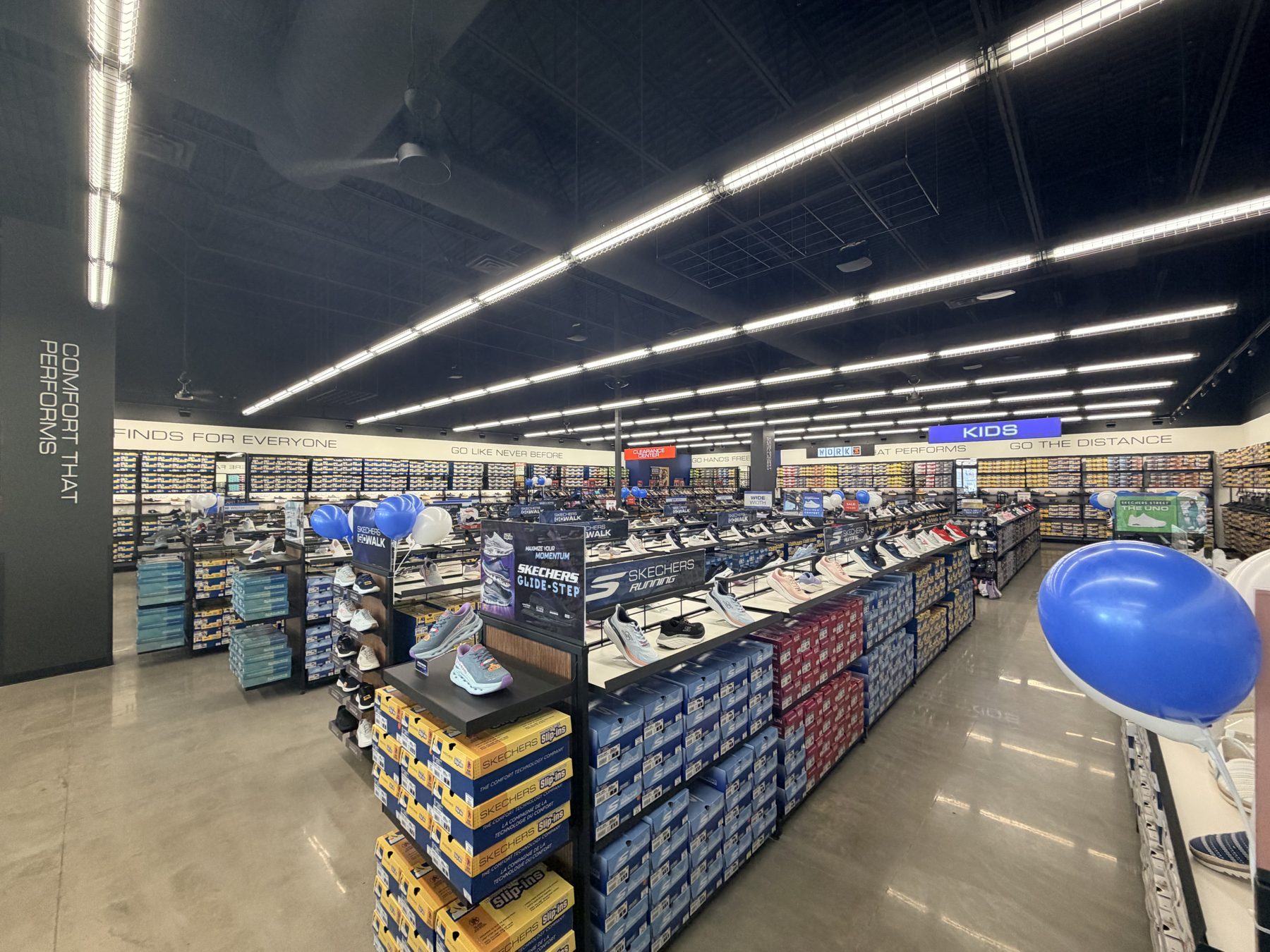 Shoe store aisles filled with shoes, boxes, and promotional balloons — Skechers (Signal Hill)