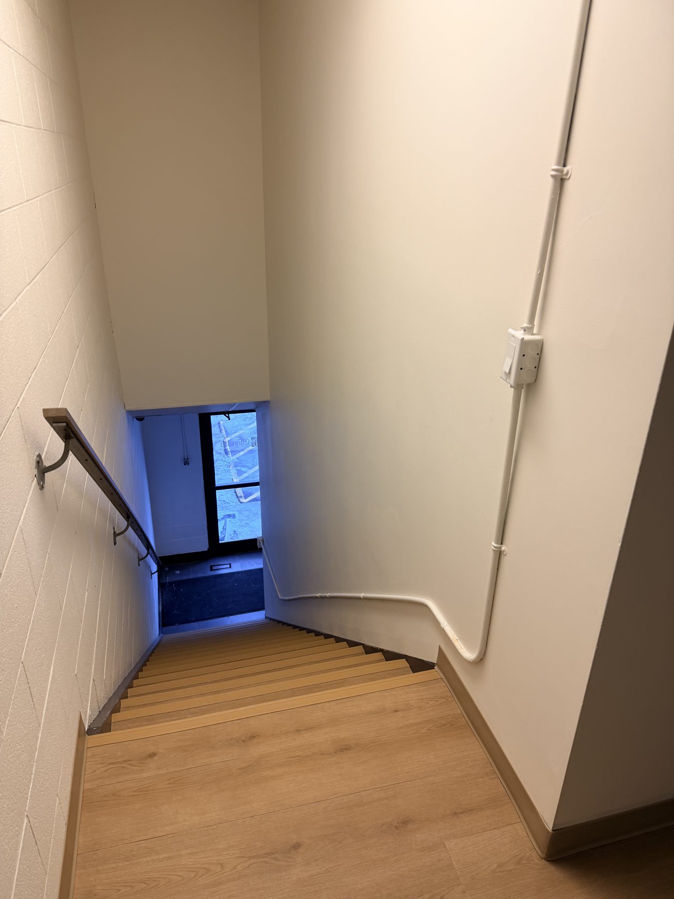 Stairwell with new wood steps, textured walls, and unfinished electrical work — The Barron Venue