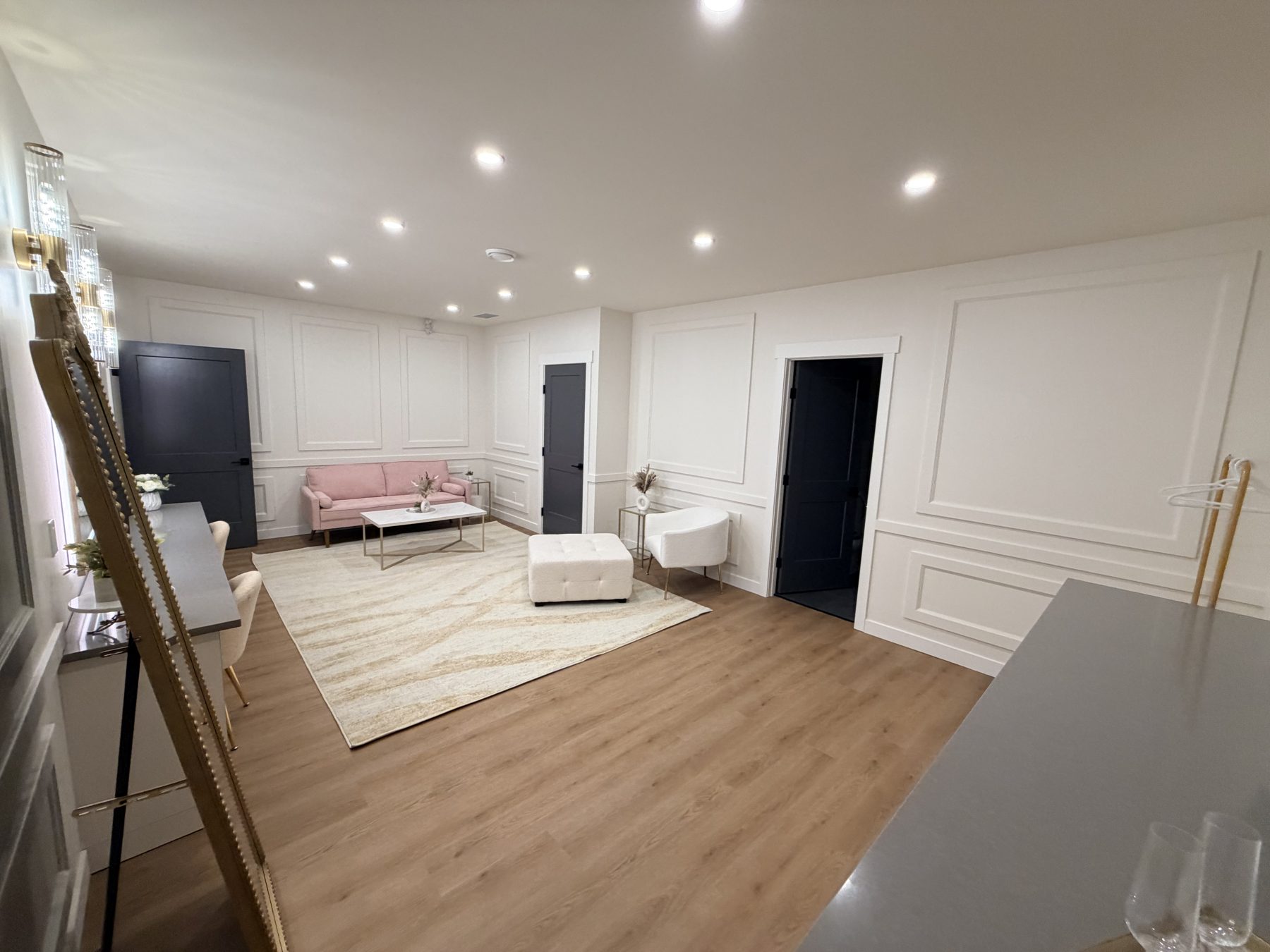Living room renovation with pink sofa, white ottoman, and wood floors — The Barron Venue