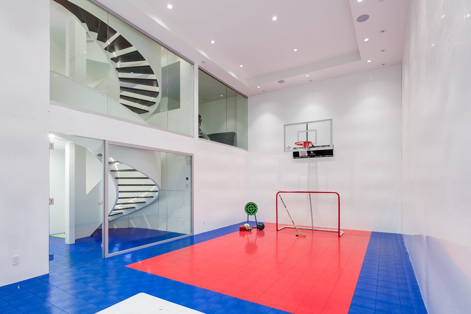 Indoor recreation room with basketball hoop, hockey net, and spiral staircase — Timeless Form