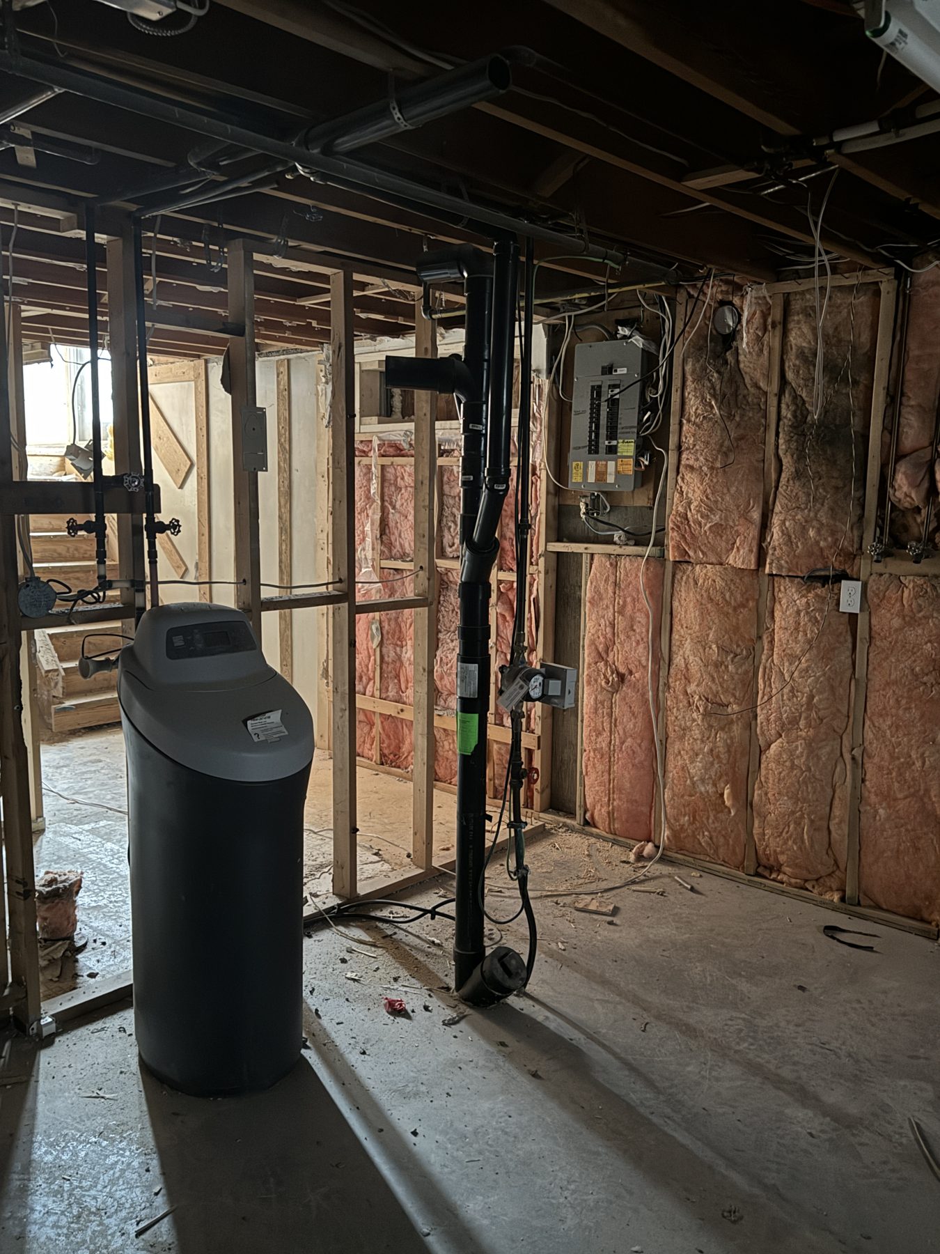 Unfinished basement with insulation, plumbing, electrical panel, and water softener — 188 Lake Adams Crescent SE, Calgary