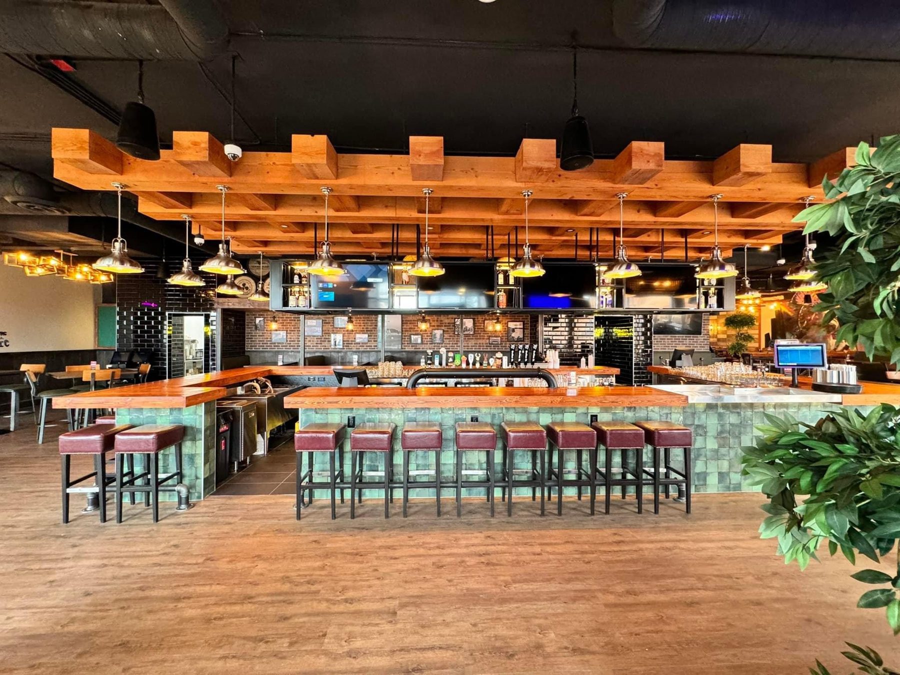 Newly renovated bar with wood beams, green tiled base, and leather stools — Blowers and Grafton (Shawnessy)