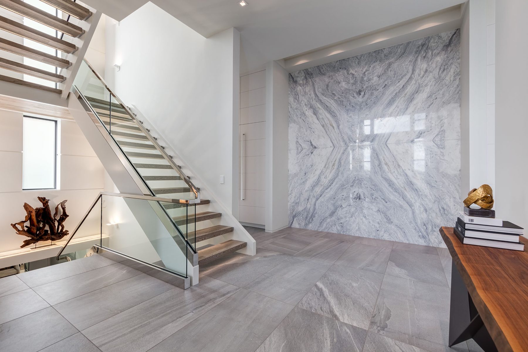 Modern staircase with glass railings and marble accent wall — Infinity