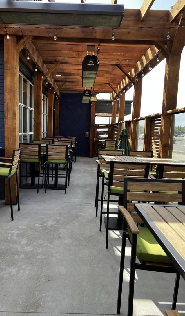 Outdoor dining area with wooden pergola, patio heaters, and bar stools — Blowers and Grafton (Lethbridge)