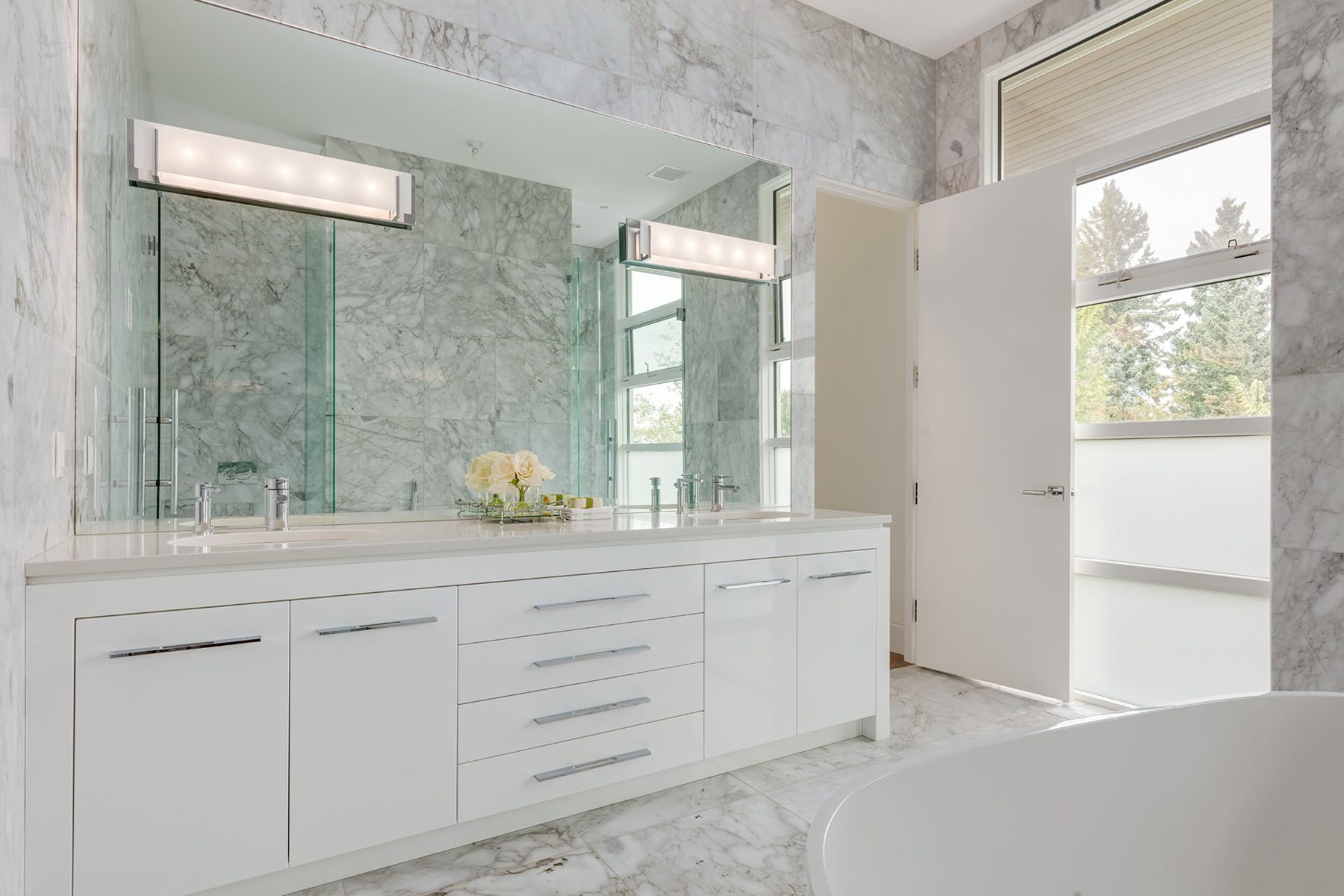 Modern bathroom with marble tiles, white vanity, and dual sinks — Germania