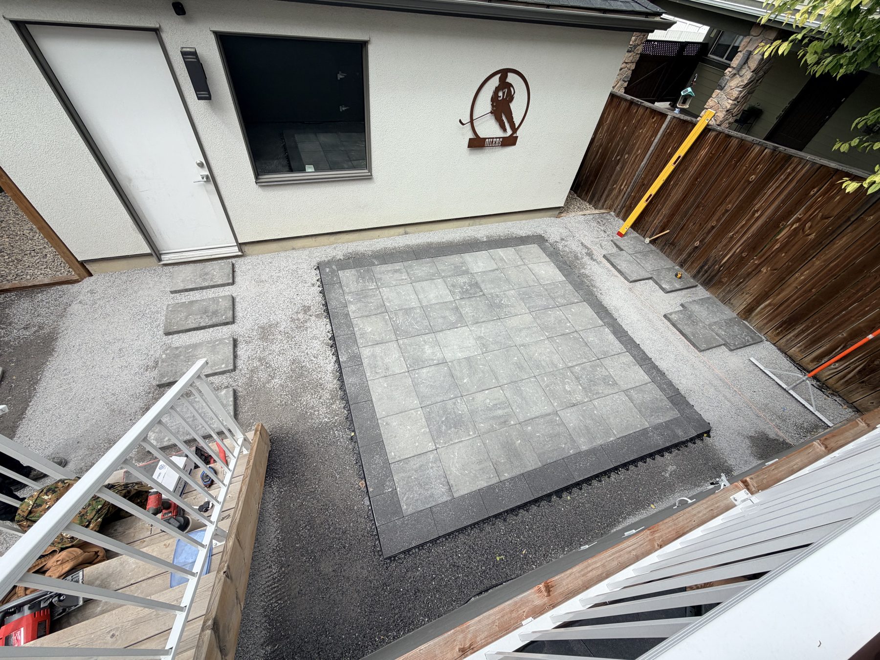 Outdoor patio paving installation with gray stone squares and gravel — 3505 41 Street SW, Calgary