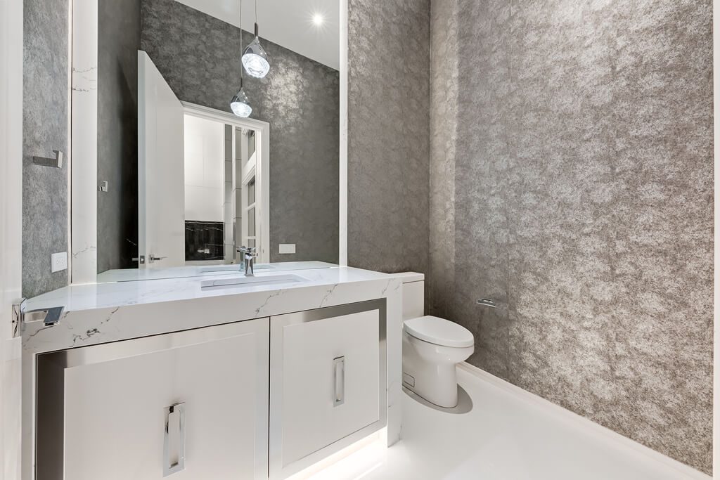 Modern bathroom with marble vanity, toilet, and textured gray walls — Blanc de Blanc