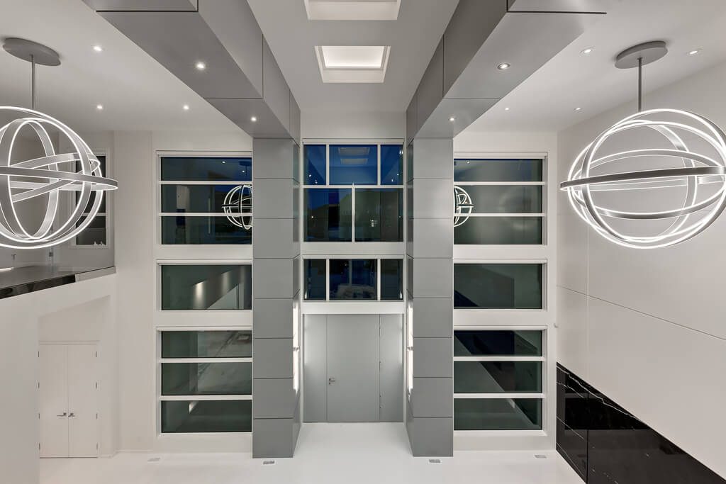 Modern atrium with floor-to-ceiling windows and globe chandeliers — Blanc de Blanc
