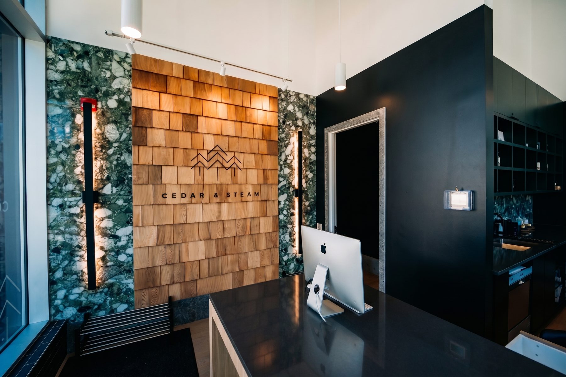 Reception area with wood plank wall, stone accents, and desk — Cedar Steam and Spa (Trinity Hills) by Onsite Contracting Services