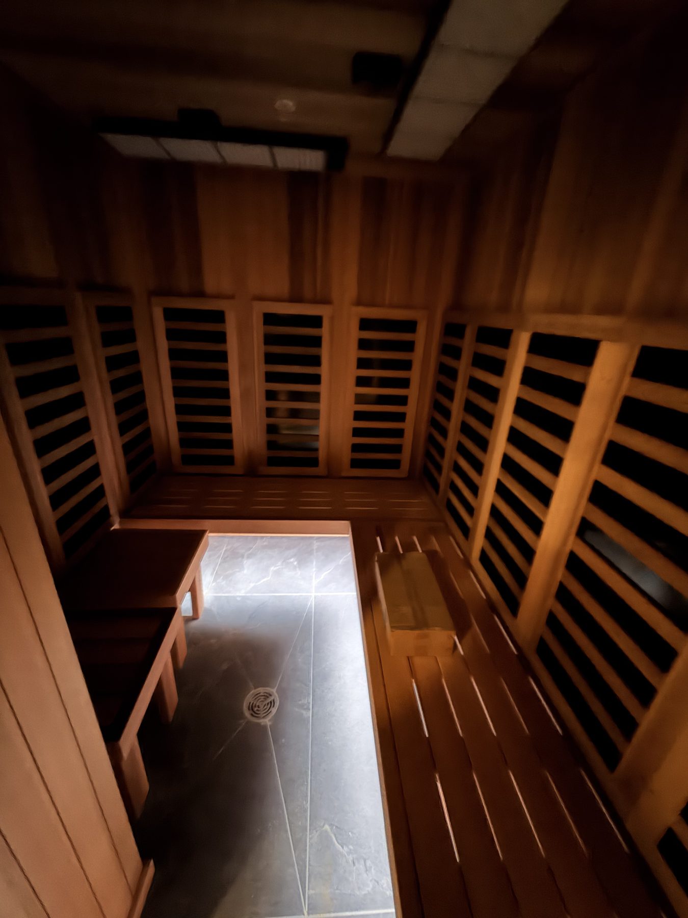 Wooden sauna interior with tiled floor and bench seating — Cedar Steam and Spa (Trinity Hills)