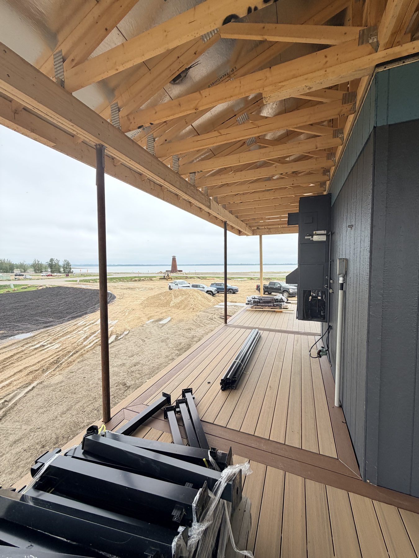 Under construction deck with wooden trusses, framing, and railing materials — Sandy Point (Club House)