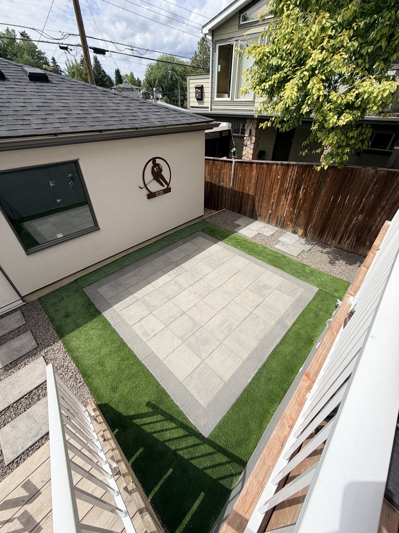 Backyard patio with pavers, artificial turf, and wood deck, nearing completion — 3505 41 Street SW, Calgary