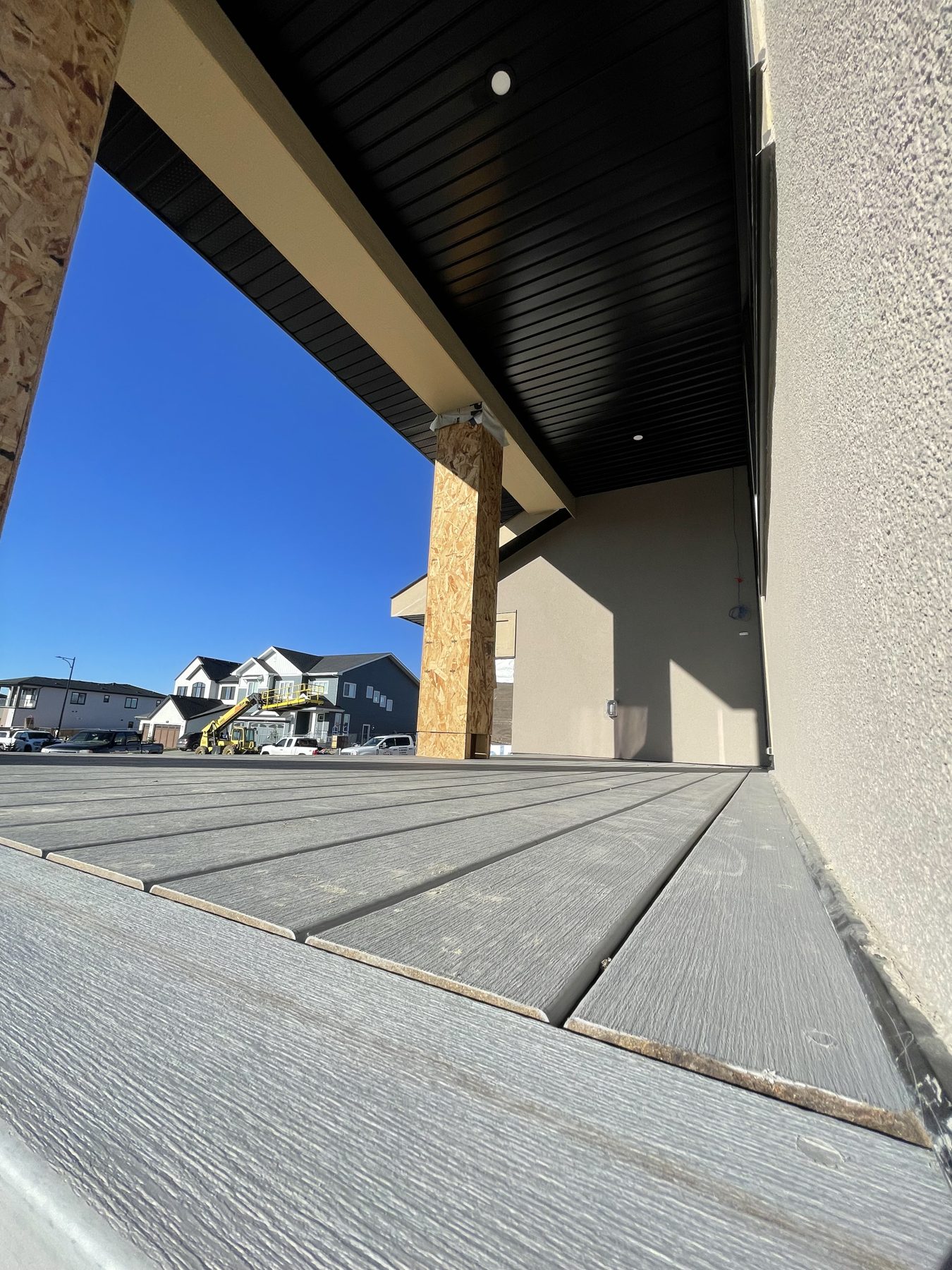 Decking installed, framing exposed, under a covered porch ceiling — 96 Fieldstone Close