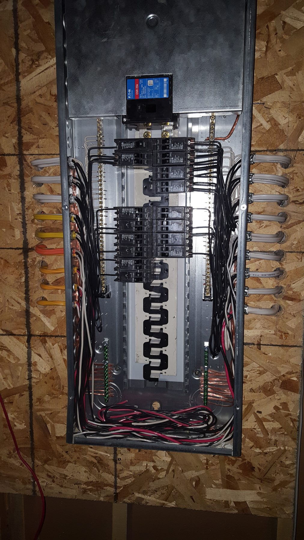 Electrical panel being wired with breakers and colorful wires installed — Briar Hill