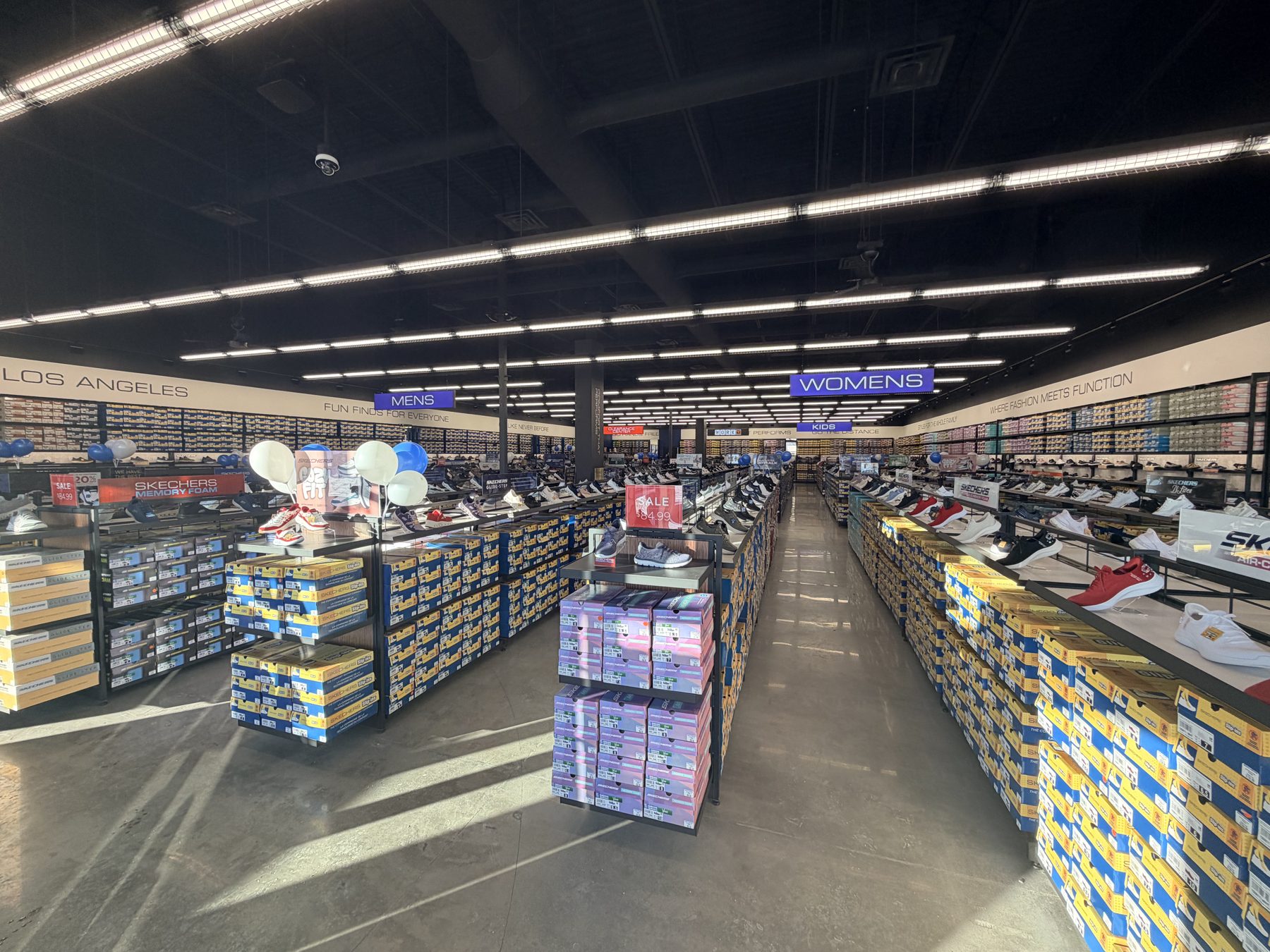 Shoe store interior with aisles of sneakers and shoe boxes — Skechers (Signal Hill)