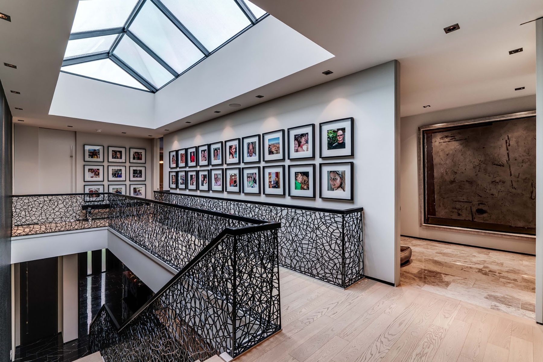 Hallway with skylight, family photos, and ornate railings — Modern Family