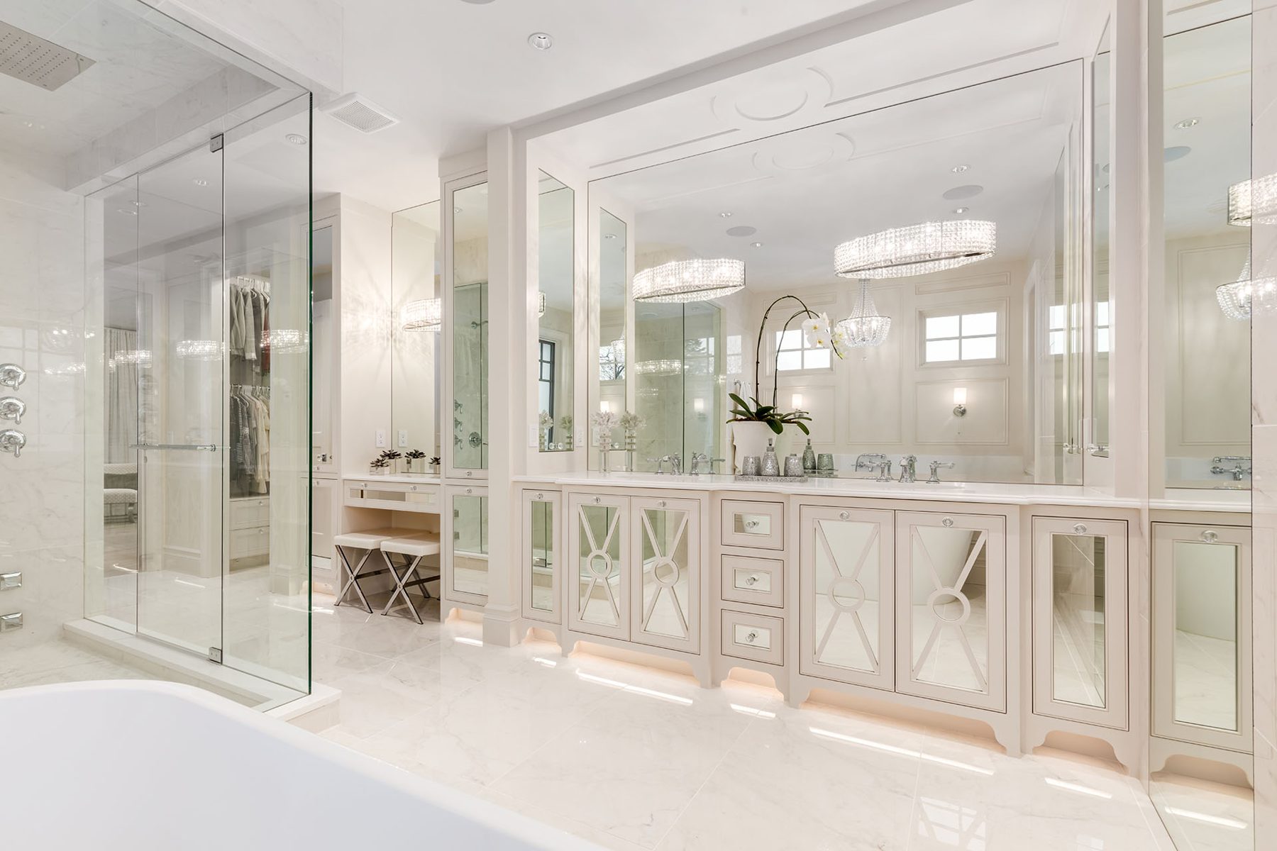 Luxurious white bathroom with double vanity, glass shower, and closet — White House