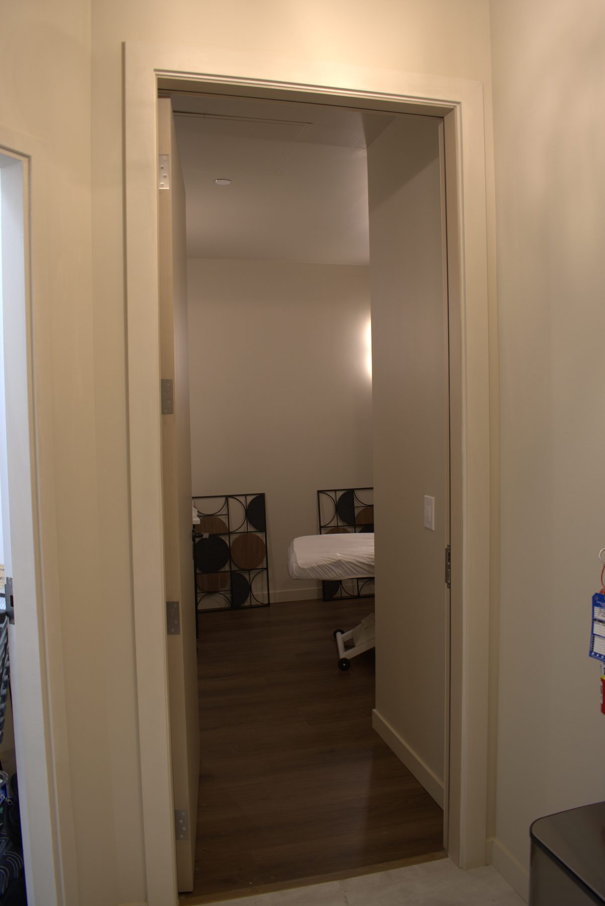 Room with massage table, wooden floor, and decorative wall hangings — Leela Spa (Bankers Hall)