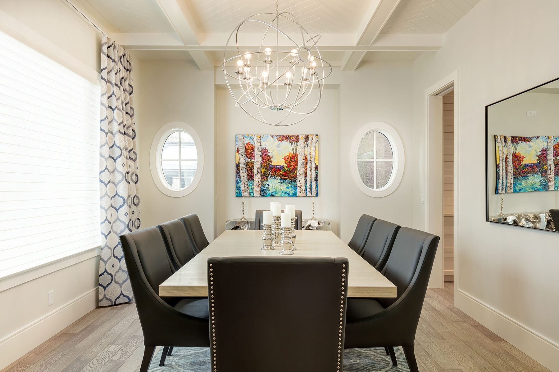 Dining room with light wood table, dark chairs, and modern chandelier — Cleret Velour
