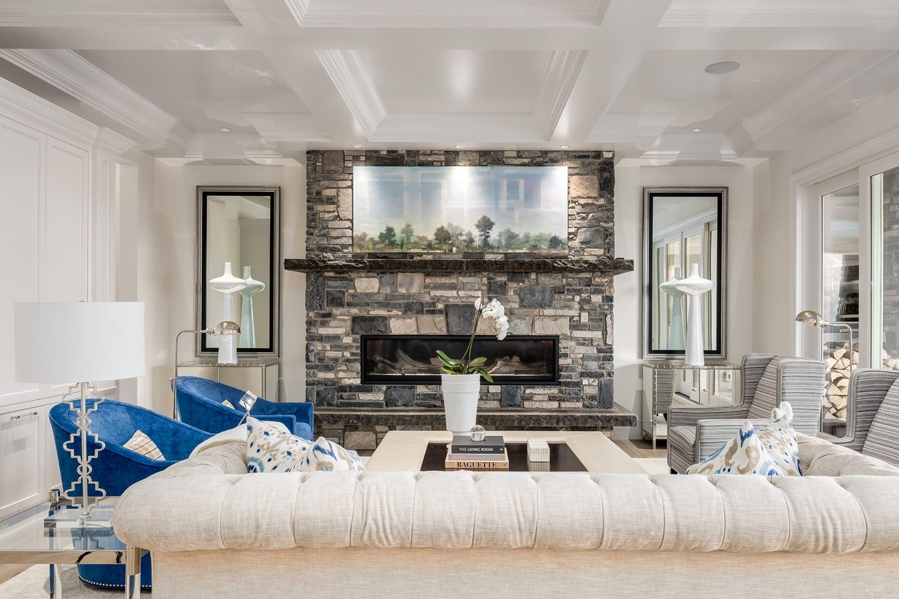 Living room with stone fireplace, tufted sofa, and blue velvet chairs — White House