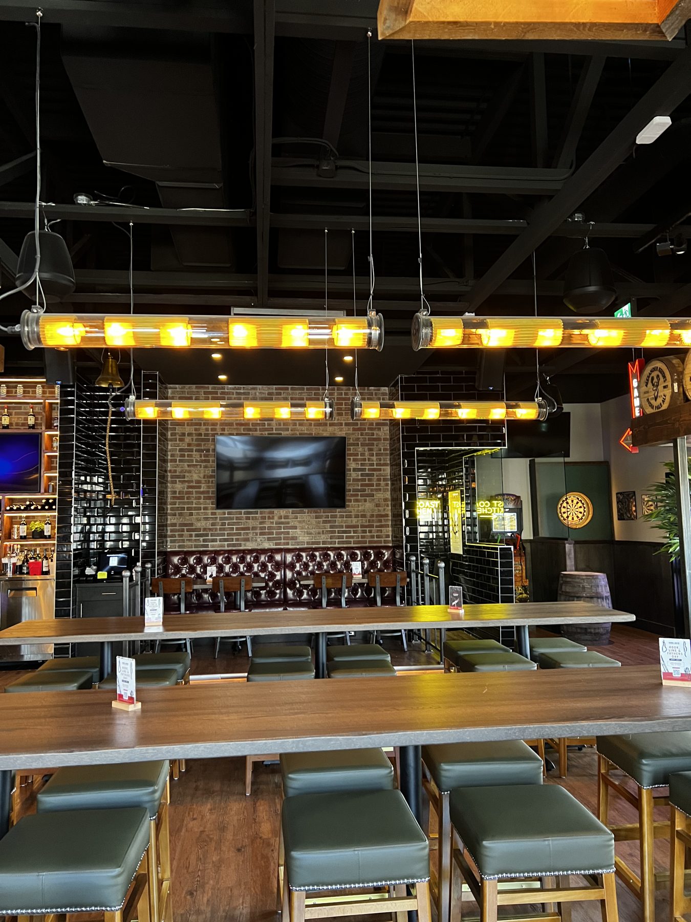 Bar interior with brick, leather booths, and modern tube lighting — Blowers and Grafton (Lethbridge) by Onsite Contracting Services