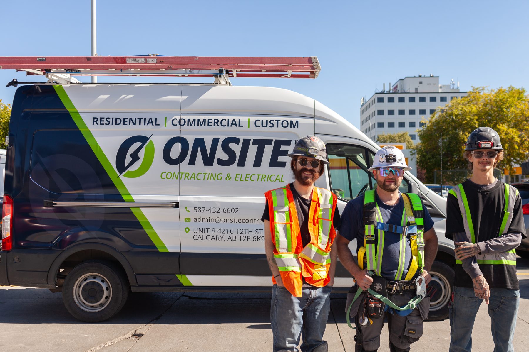 Three construction workers stand by a branded contracting van — Old Navy Chinook