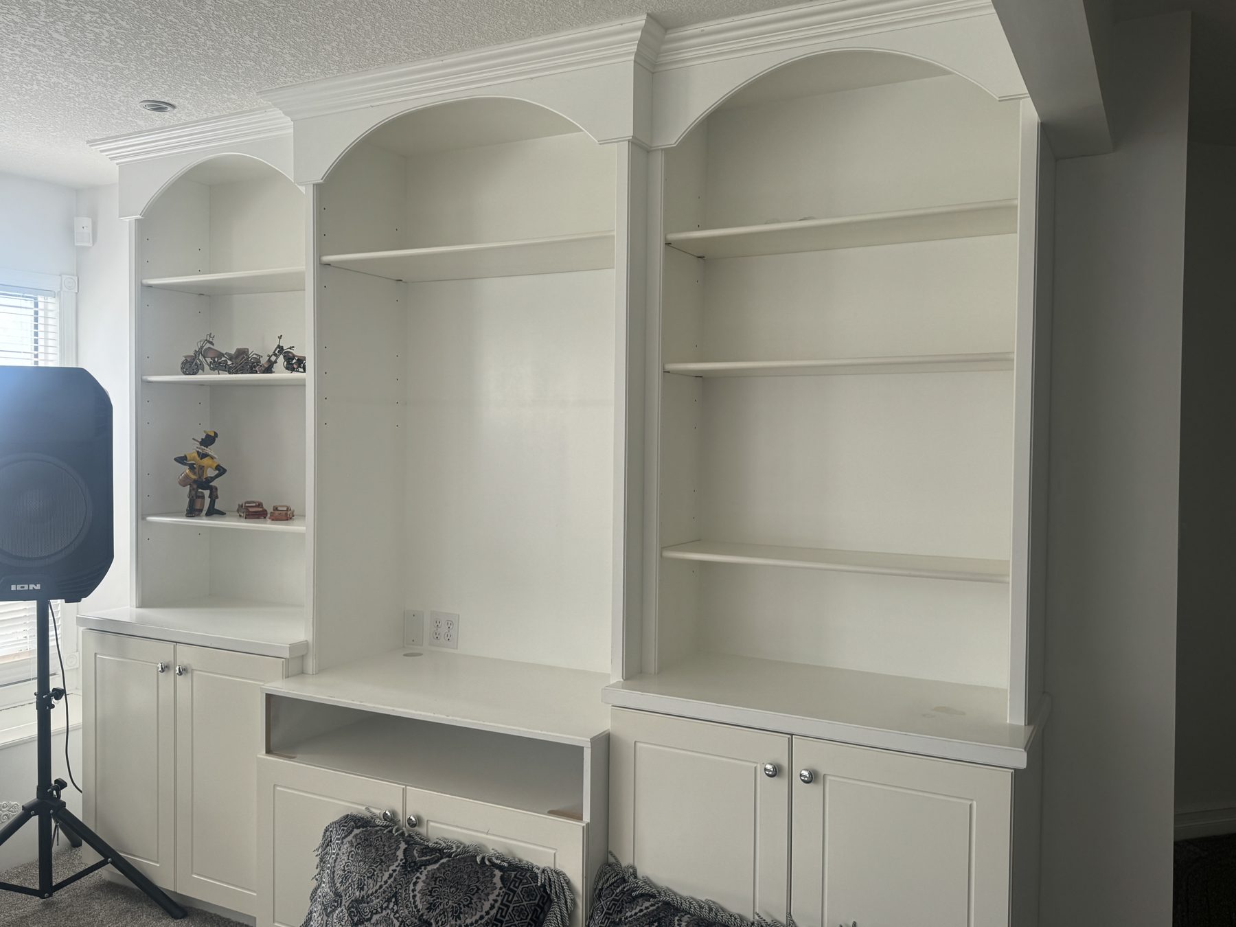 White built-in shelving unit with cabinets, partially decorated — 14 Lochend Drive, Cochrane