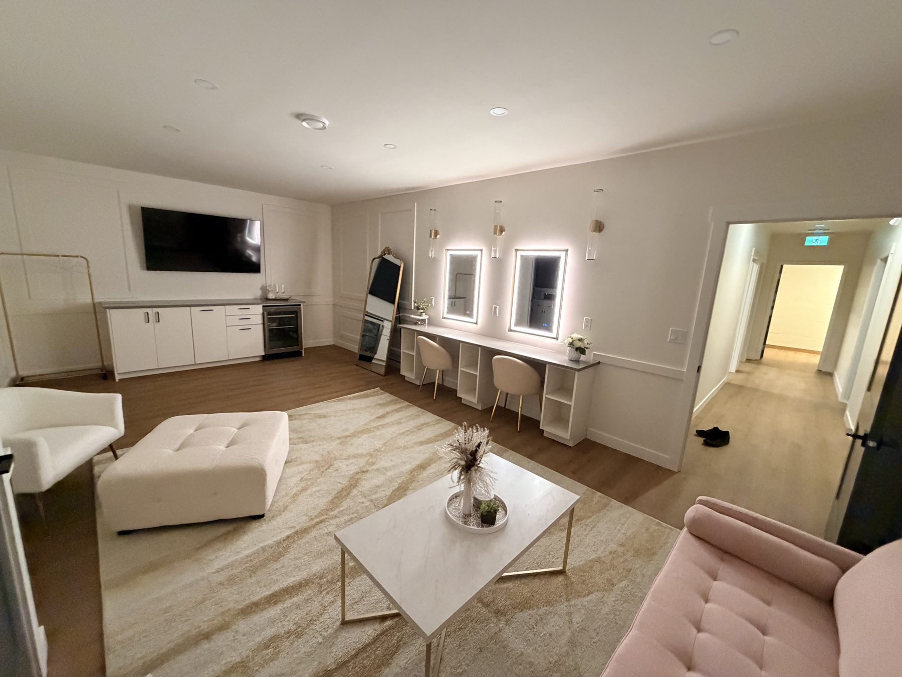 Dressing room with vanity mirrors, white cabinets, and seating — The Barron Venue