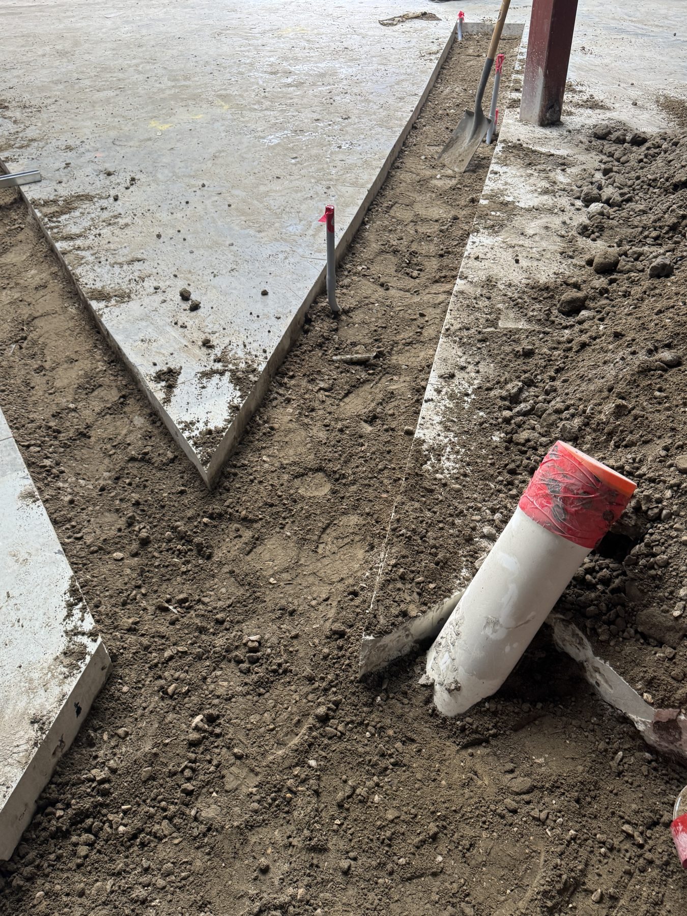 Trench dug in concrete floor for plumbing installation, exposed pipe — Blowers and Grafton (Red Deer)