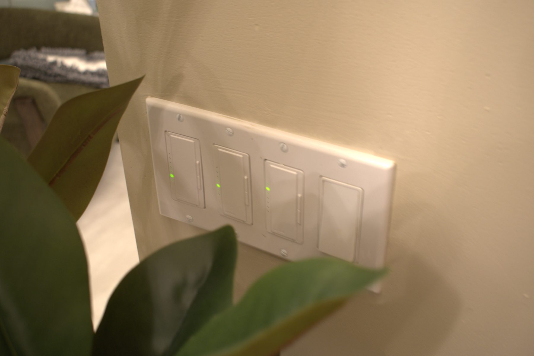 Smart light switches with green indicators on a beige wall — Leela Spa (Bankers Hall)