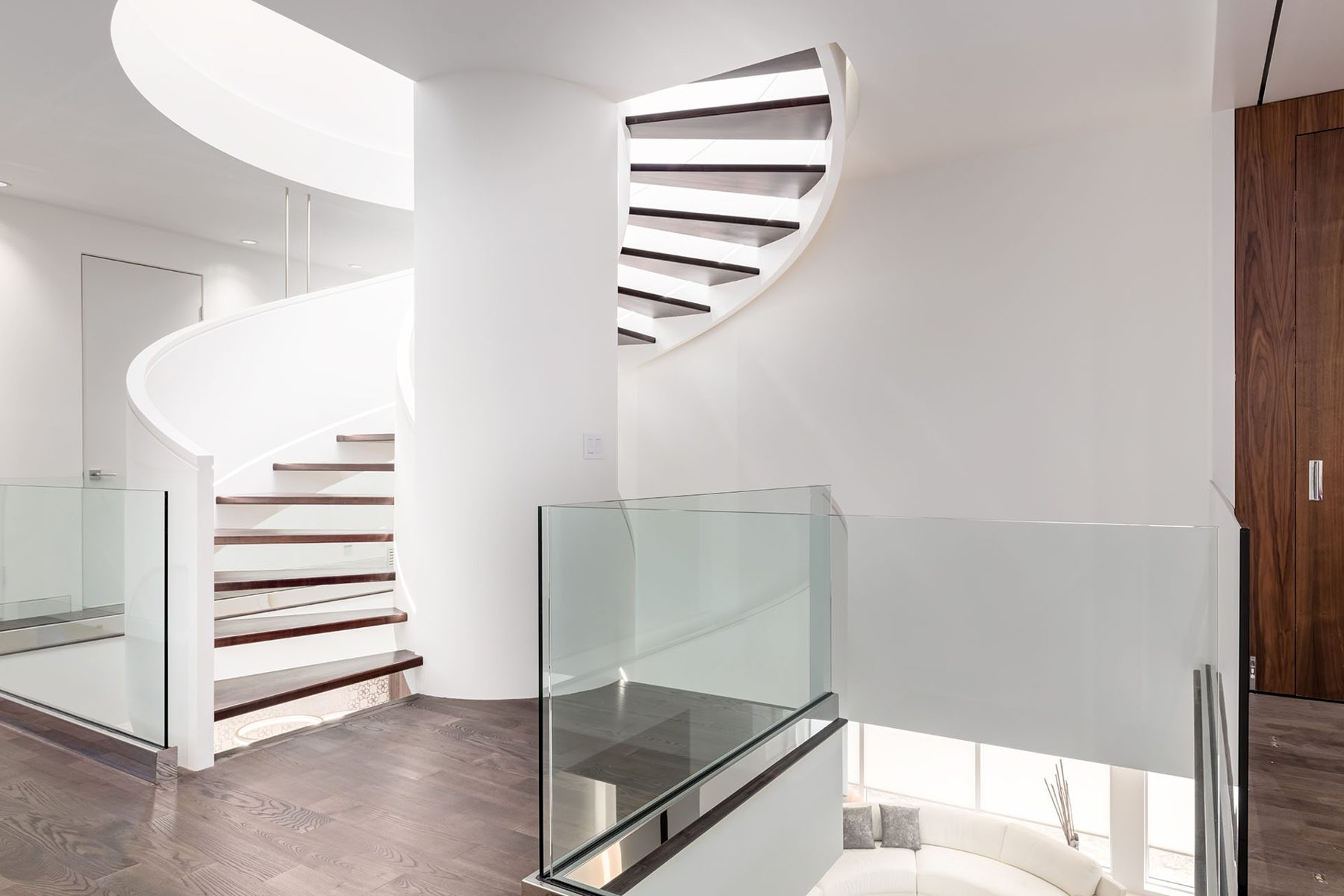 Modern staircase with white walls, glass railings, and dark wood treads — Timeless Form