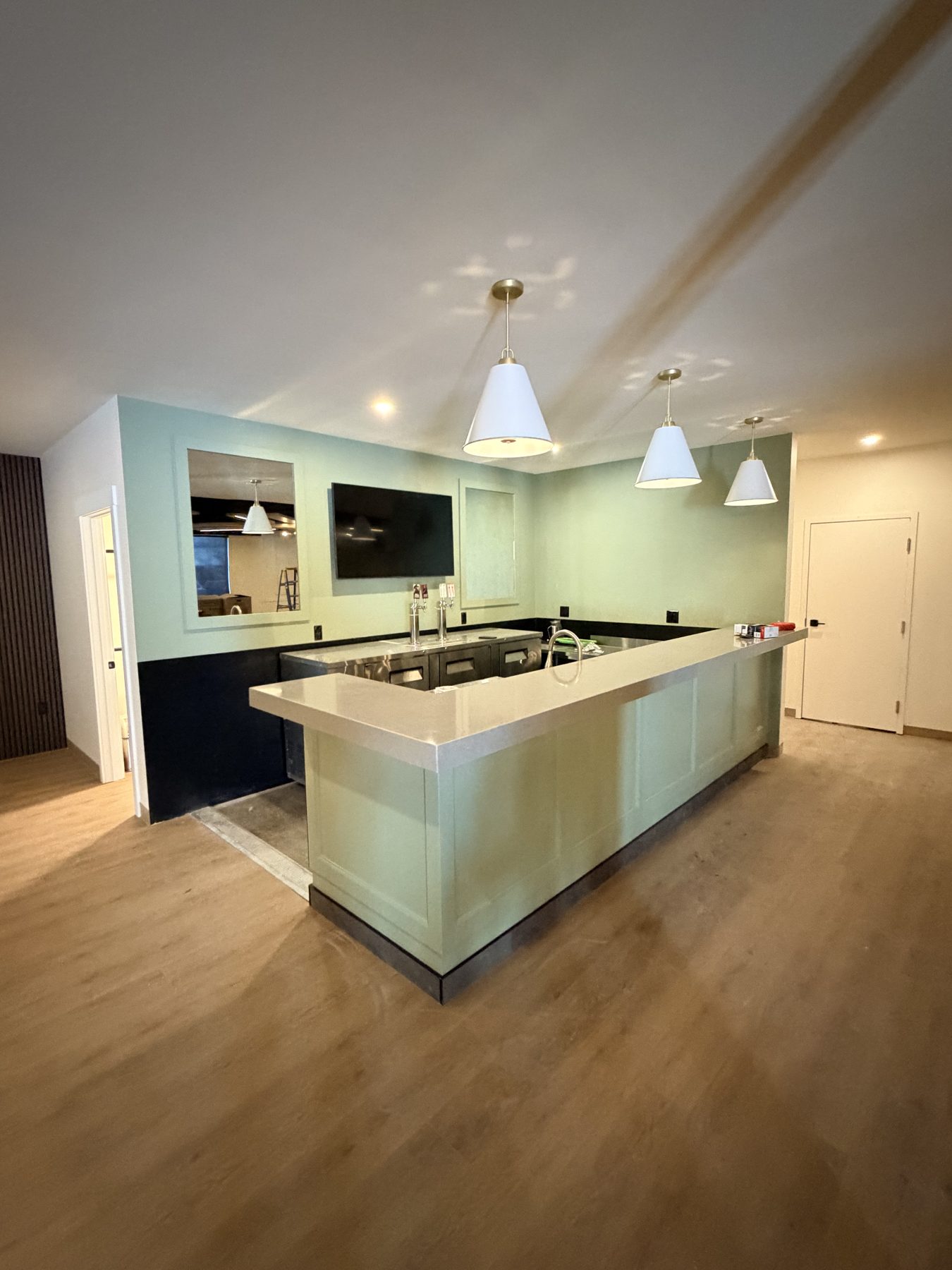 Newly installed bar with pale green cabinets and stone countertop — The Barron Venue