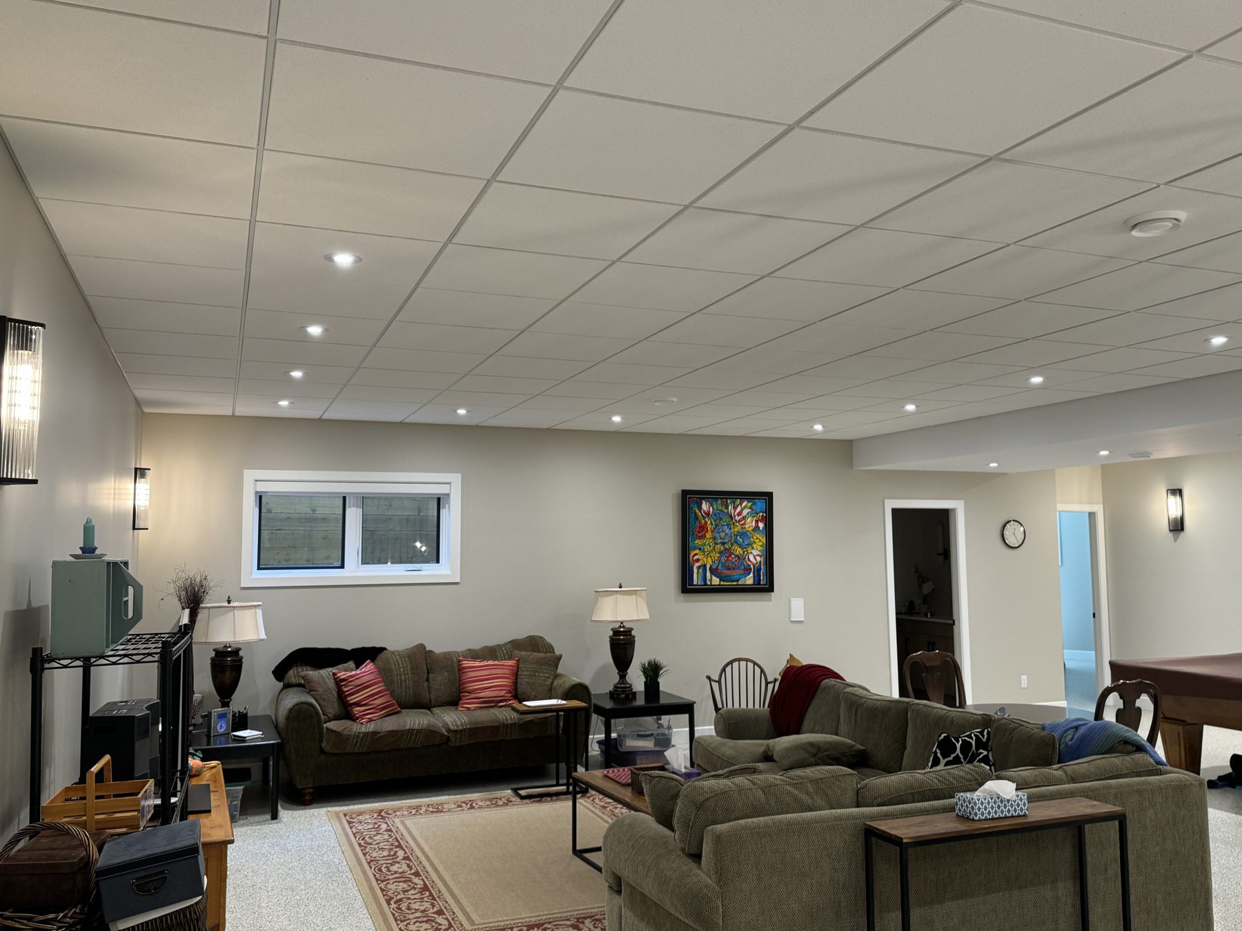 Finished basement living room with couches, artwork, and pendant lighting — 18 Varsplain Place Northwest