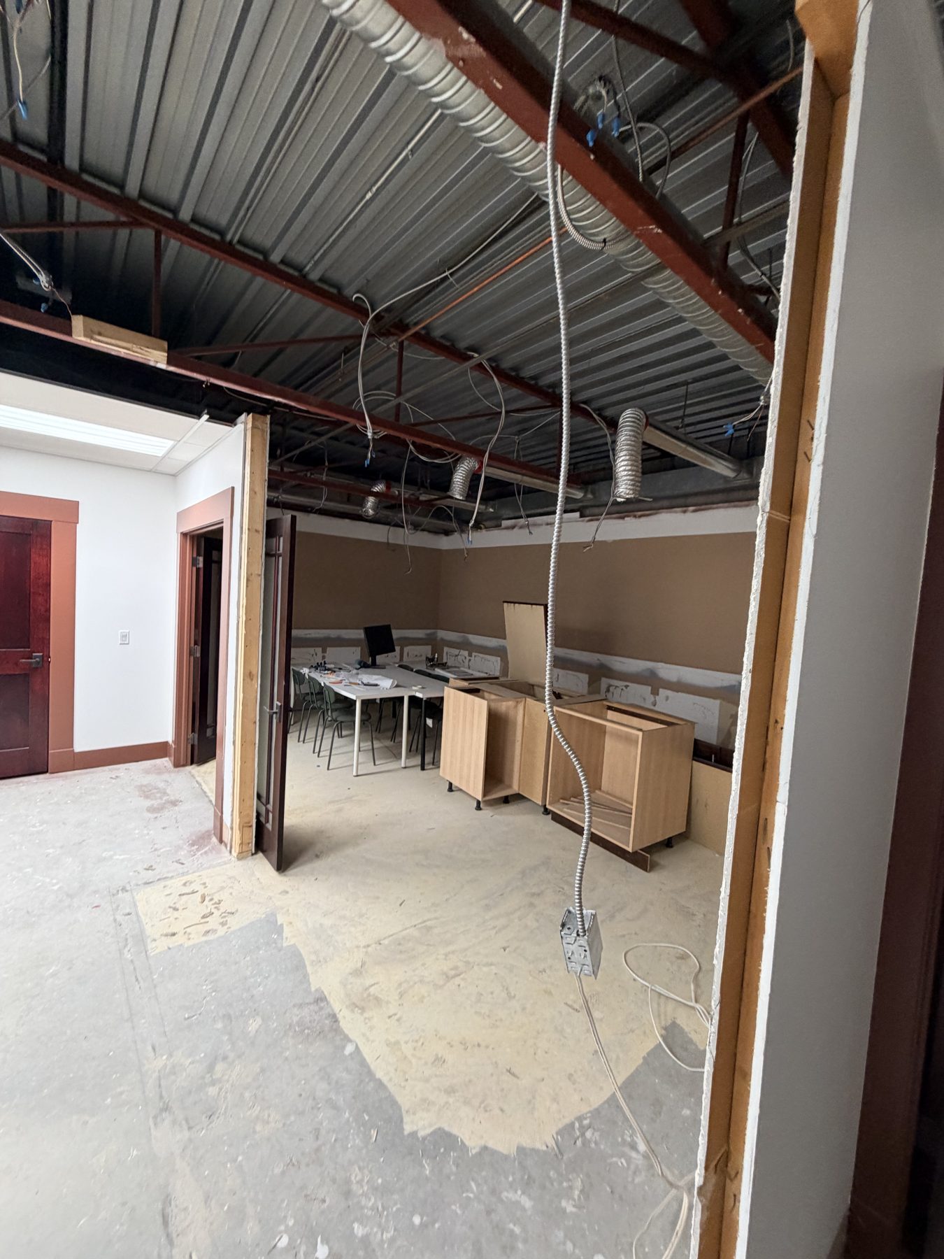 Unfinished room with exposed ceiling, ductwork, cabinets, and wiring — The Barron Venue