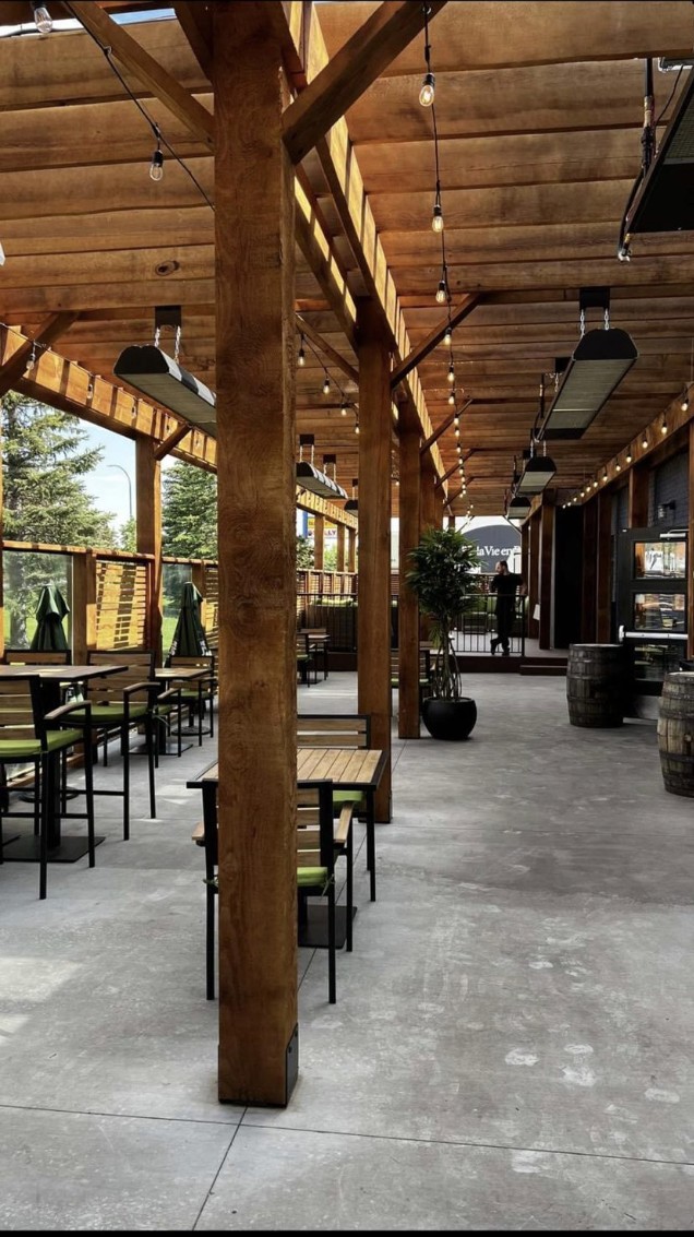 Outdoor patio with wooden beams, tables, chairs, and heaters — Blowers and Grafton (Lethbridge)