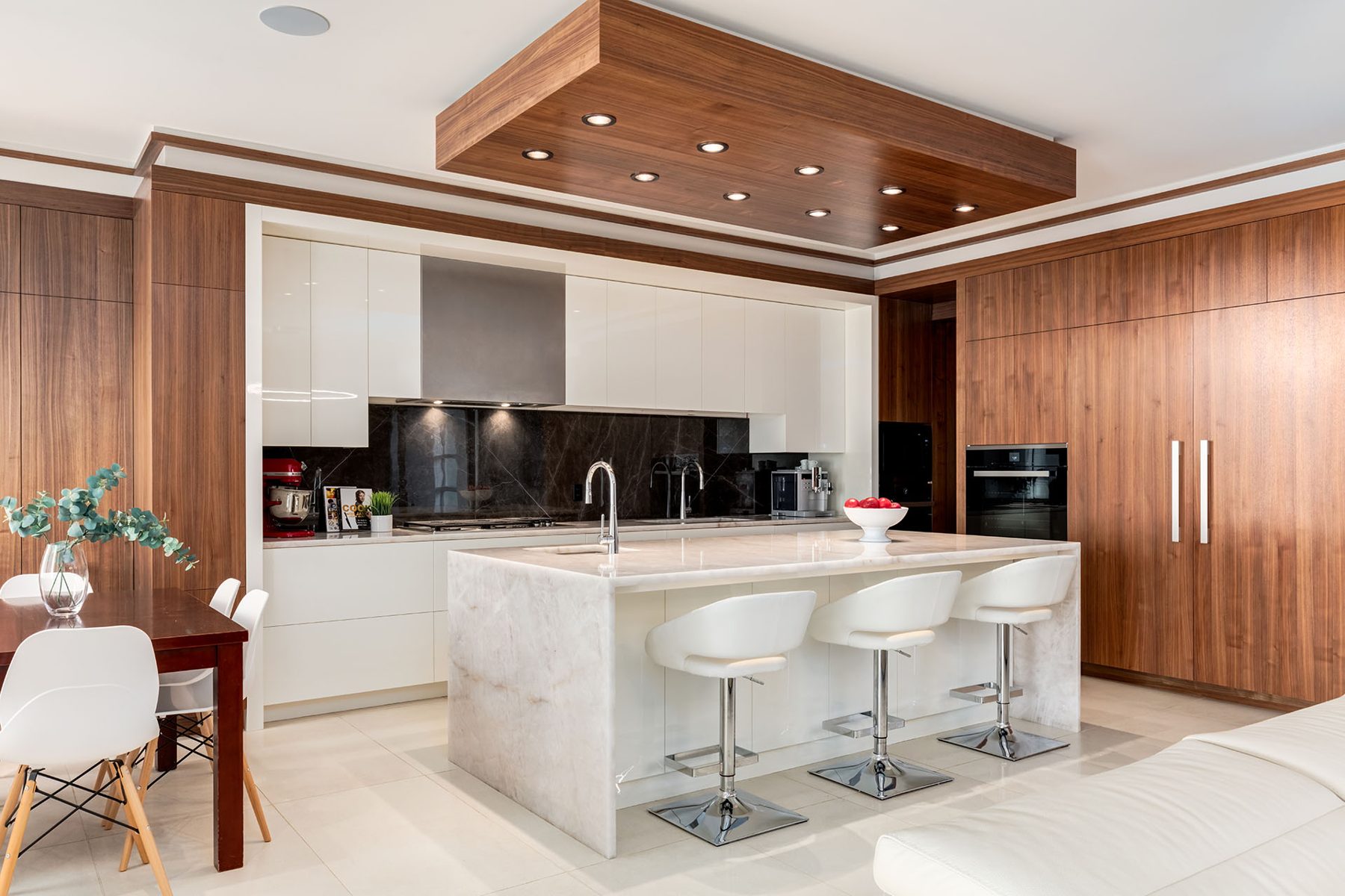 Modern kitchen with white cabinets, marble island, and wood-paneled walls — Timeless Form