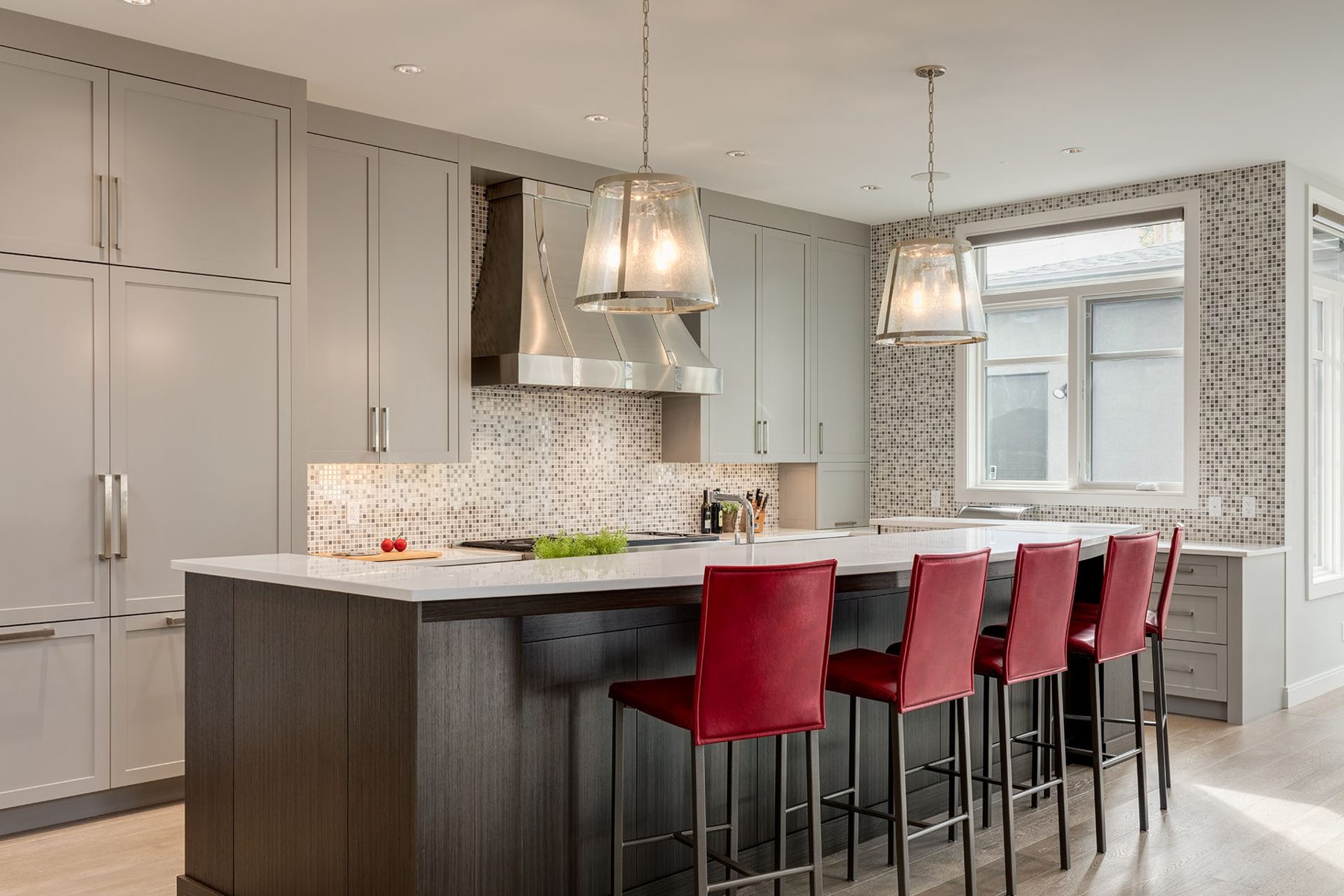 Modern kitchen with grey cabinets, white counters, red bar stools — The Cellar by Onsite Contracting Services