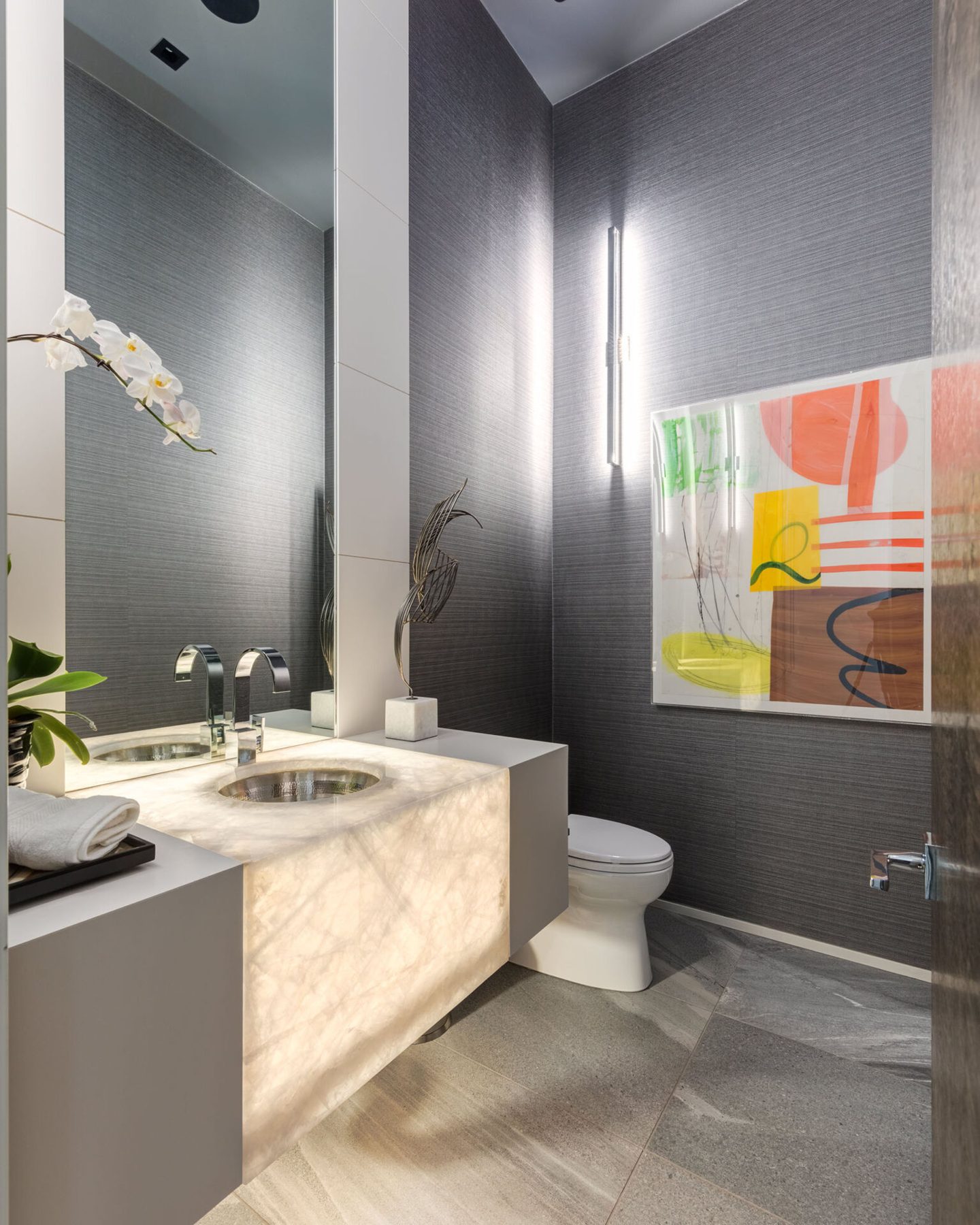 Modern bathroom with backlit marble vanity, vessel sink, and colorful art — Infinity
