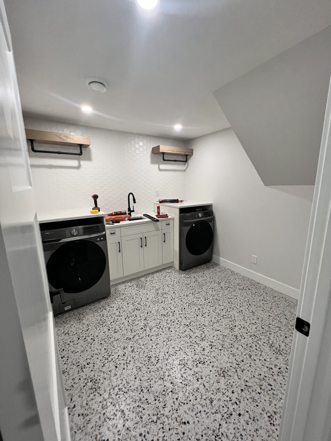 Laundry room renovation with new cabinets, sink, and flooring underway — 720 Lake Twintree Crescent SE, Calgary