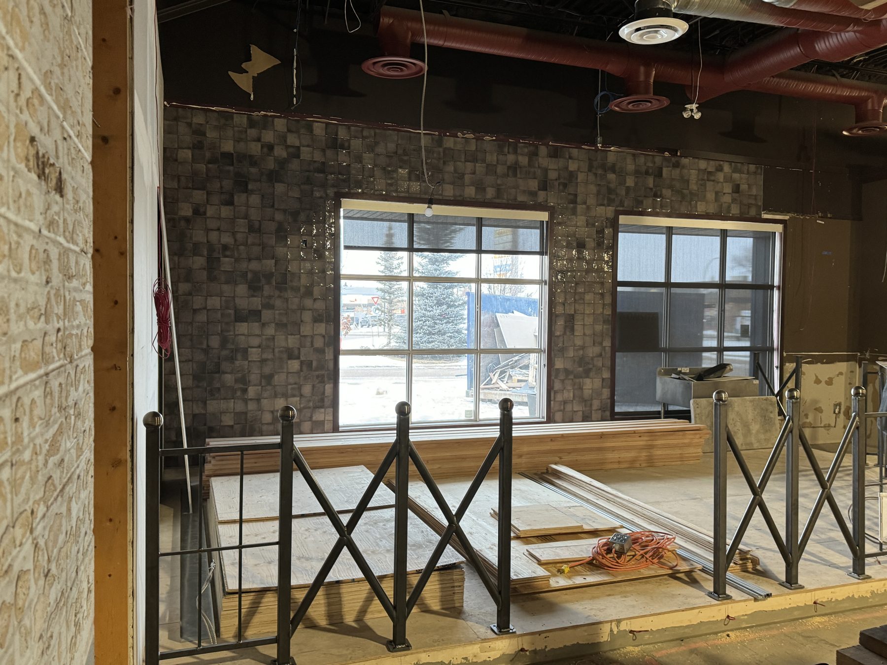 Tiled wall, unfinished floor, construction materials, and metal railing — Blowers and Grafton (Medicine Hat)
